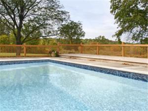 a swimming pool in front of a wooden fence at Days Inn by Wyndham Middletown in New Hampton
