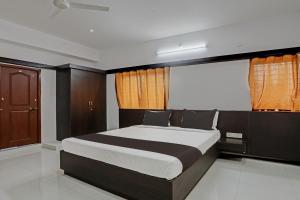 a bedroom with a large bed in a room at Super Collection O Emara Grand Mysore in Mysore