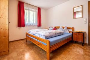 a bedroom with a bed and a red window at Haus Kofler in Racines