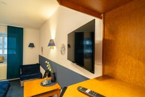 SurwoldにあるWaldhotel Surwoldのテレビ、ソファ、椅子が備わる客室です。