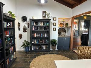 a living room with a book shelf filled with books at Palm Breeze - 4 bedroom -Walk to the beach in Bargara