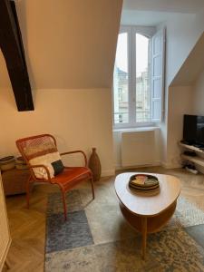 a living room with a chair and a table at Canopée - Appartement - Hyper centre ville in Quimper