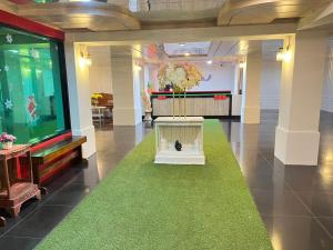 eine Lobby mit einem großen TV und einem grünen Teppich in der Unterkunft The Chilli Patong Beach Hotel - Near to the Beach -Completed Fully renovate 2023 in Patong Beach
