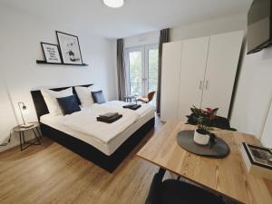 1 dormitorio con cama extragrande y mesa en CASA BLACK-Zentral-Outlet-Aufzug-Stylisch-Unique en Metzingen