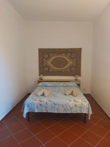 una piccola camera con letto con testiera di Villa Secchi bifamiliare sul mare IUNP4784 a Sorso