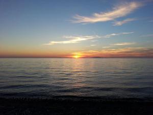 un tramonto su un corpo d'acqua con il tramonto di Villa Secchi bifamiliare sul mare IUNP4784 a Sorso