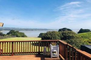 einen Holzbalkon mit Blick auf das Wasser in der Unterkunft Te Papatapu Retreat in Raglan