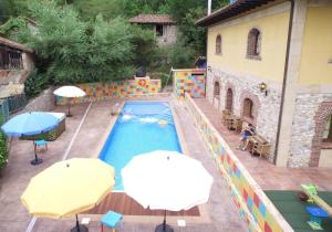 an outdoor swimming pool with two umbrellas and a building at Hotel Trapa in Soto de Cangas