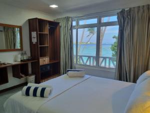 Schlafzimmer mit einem Bett und Meerblick in der Unterkunft Batuta Maldives Surf View in Thulusdhoo