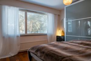 a bedroom with a bed and a large window at Nordic Gem near railway station, free parking and wifi in Rovaniemi