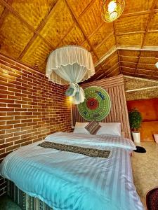 um quarto com uma cama numa parede de tijolos em Du Gia Cozy Homestay & Tours em Làng Cac