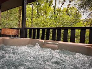 a bath tub filled with water next to a fence at Woodland Lodge’s St Clears in Carmarthen