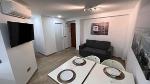 a small living room with a table and a couch at luminoso apartamento 6 personas pueblo nuevo in Madrid