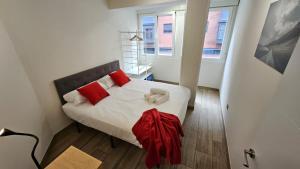 a small bedroom with a bed with red pillows at luminoso apartamento 6 personas pueblo nuevo in Madrid