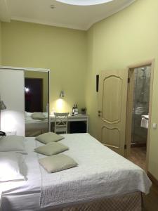 ein Schlafzimmer mit einem Bett mit zwei Kissen darauf in der Unterkunft Frapolli Hotel in Odessa