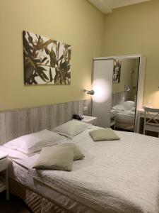 a bedroom with a large bed and a mirror at Frapolli Hotel in Odesa