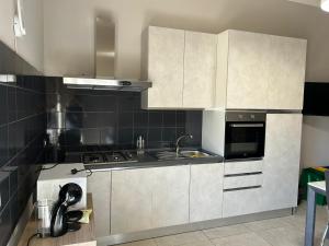 a kitchen with white cabinets and a stove at Dimora Sant'Agata in Catania