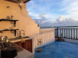 a kitchen with a view of the ocean on a balcony at Pwani House - Lamu Seafront in Lamu