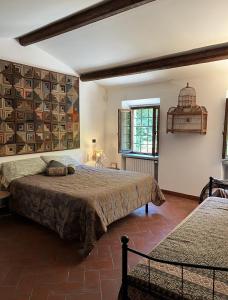 1 dormitorio con 2 camas y una jaula de aves en la pared en Molin Barletta - Nice Holiday House With Private Pool Marliana, Toscana, en Marliana