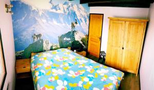a bedroom with a bed with a painting on the wall at Chalet Le Remarquable, Crest Voland in Crest-Voland