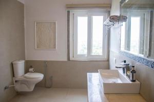 a bathroom with a toilet and a sink and a window at Titardi Garh- 18th Century Castle Homestay in Udaipur +51 photos