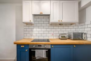 een keuken met blauwe kasten en een aanrecht bij The Riverside Hideaway - Stockbridge in Edinburgh