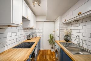 a kitchen with blue cabinets and a sink at The Riverside Hideaway - Stockbridge in Edinburgh