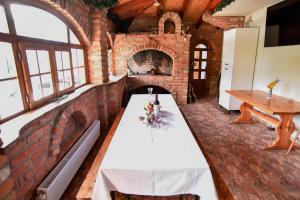 a long table in a room with a brick fireplace at Budimberg Kuća za odmor s bazenom in Ludbreg