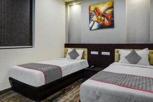 Cette chambre comprend deux lits et un tableau mural. dans l'établissement Townhouse 1199 Hotel Dev's Inn by CJ, à Gunadala