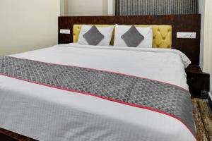 een slaapkamer met een groot bed met witte lakens en kussens bij Townhouse 1199 Hotel Dev's Inn by CJ in Gunadala