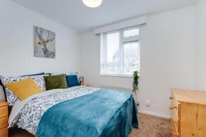 a bedroom with a bed and a window at Lovely 3bed split level flat with outside space in London