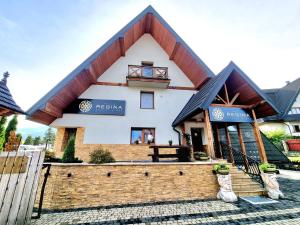 una casa con techo de gambrel en Willa Regina II Resort & SPA en Zakopane