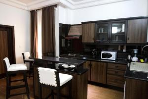 a kitchen with a counter with chairs and a microwave at Mosaly Residence Caboma in Cotonou