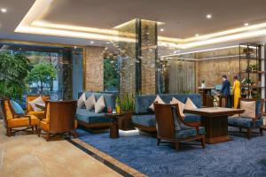 a lobby with couches and tables in a building at Gloud Hotel in Hanoi