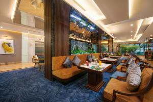 un vestíbulo de un hotel con sofás y mesas en Gloud Hotel, en Hanói