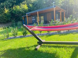 a hammock in the grass in front of a cabin at Tiny House by the forest 1 