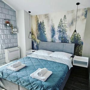 Un dormitorio con una cama azul con toallas. en Apartmani Drijen en Ravno