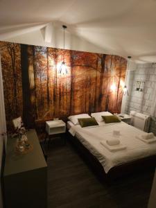a bedroom with two beds and a painting on the wall at Apartmani Drijen in Ravno