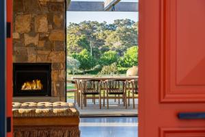 Habitación con chimenea y mesa con sillas. en Ginahgulla Olive Estate I Private Properties, en Margaret River Town