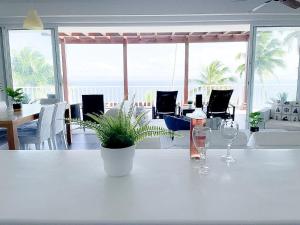 einem weißen Tisch mit zwei Gläsern und einer Pflanze darauf. in der Unterkunft Saman - Paradise With A View - Vista Mare in Santa Bárbara de Samaná