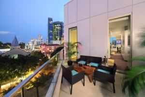 a balcony with a table and chairs on a building at Park Regis Singapore in Singapore