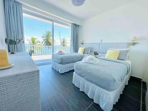 サンタ・バーバラ・デ・サマナにあるSaman - Paradise With A View - Vista Mareのベッド2台とバルコニーが備わるホテルルームです。
