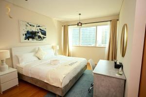 a bedroom with a bed and a desk and a window at Starlight 1BR Apartment: Retreat for Your Getaway in Abu Dhabi