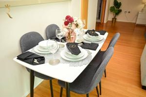 a white dining room table with chairs and a white table cloth at 1BR Apartment Retreat for Your Getaway In Al Muneera in Abu Dhabi