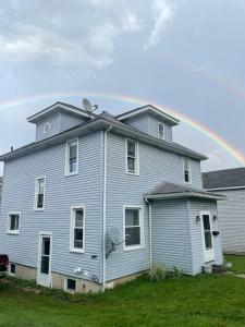 uma grande casa azul com um arco-íris ao fundo em Cozy Haven Retreat em Saint Marys