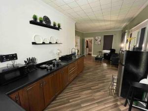 cocina con suelo de madera y encimera negra en Cozy Haven Retreat, en Saint Marys