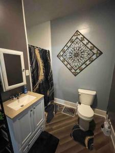 een badkamer met een toilet, een wastafel en een spiegel bij Cozy Haven Retreat in Saint Marys