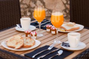 una mesa con platos de comida y vasos de zumo de naranja en Hotel Villa Miramar en Poo de Llanes