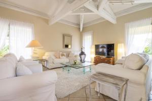a living room with white furniture and a tv at Villa Ambre in Digne-les-Bains