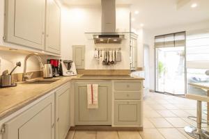 a kitchen with white cabinets and a stove top oven at Villa Ambre in Digne-les-Bains